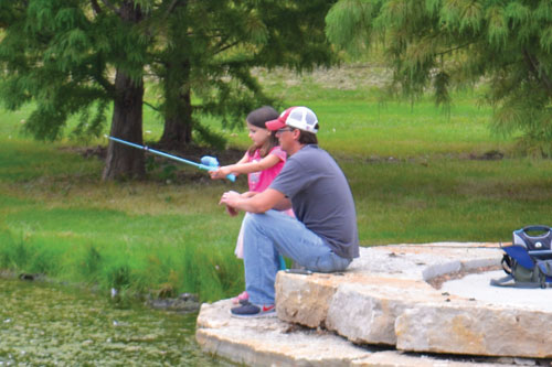 Photo of a father and child at the fishing derby.