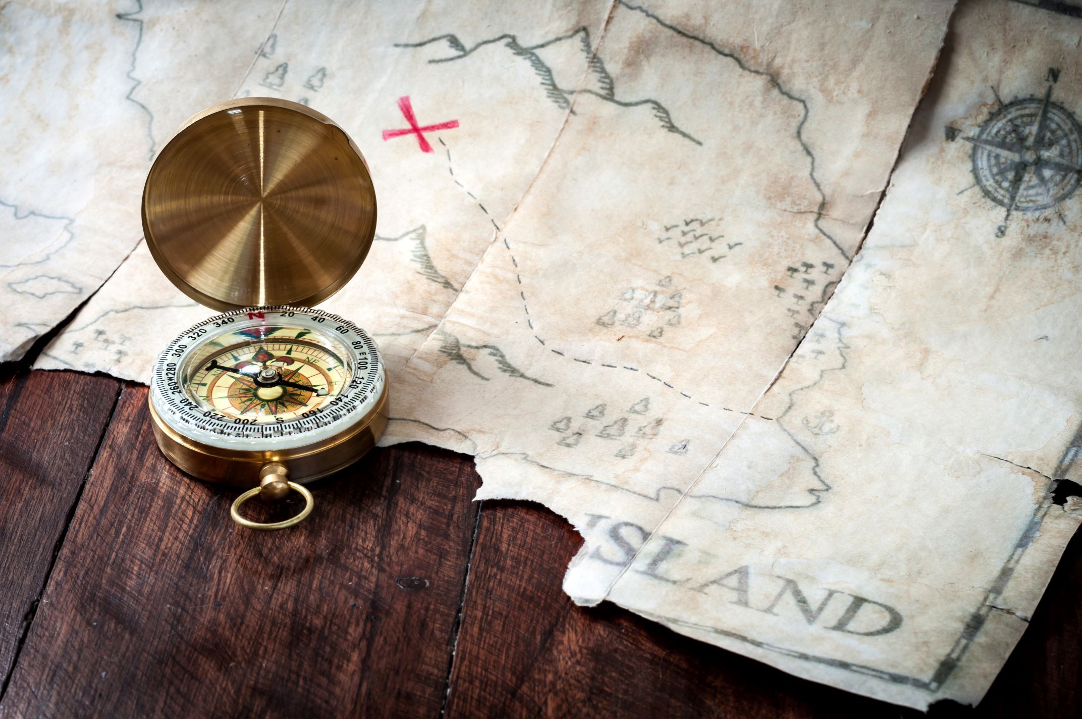 Photo of compass and treasure map.