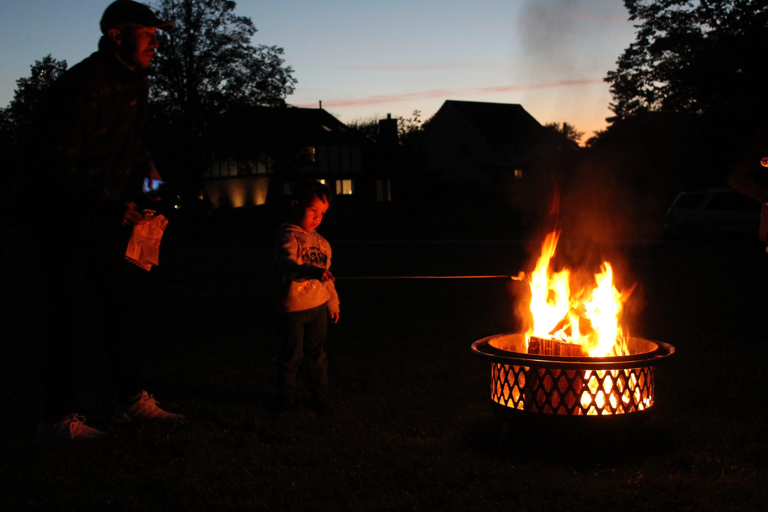 Photo of group roasting marshmallows at the community bonfire event.