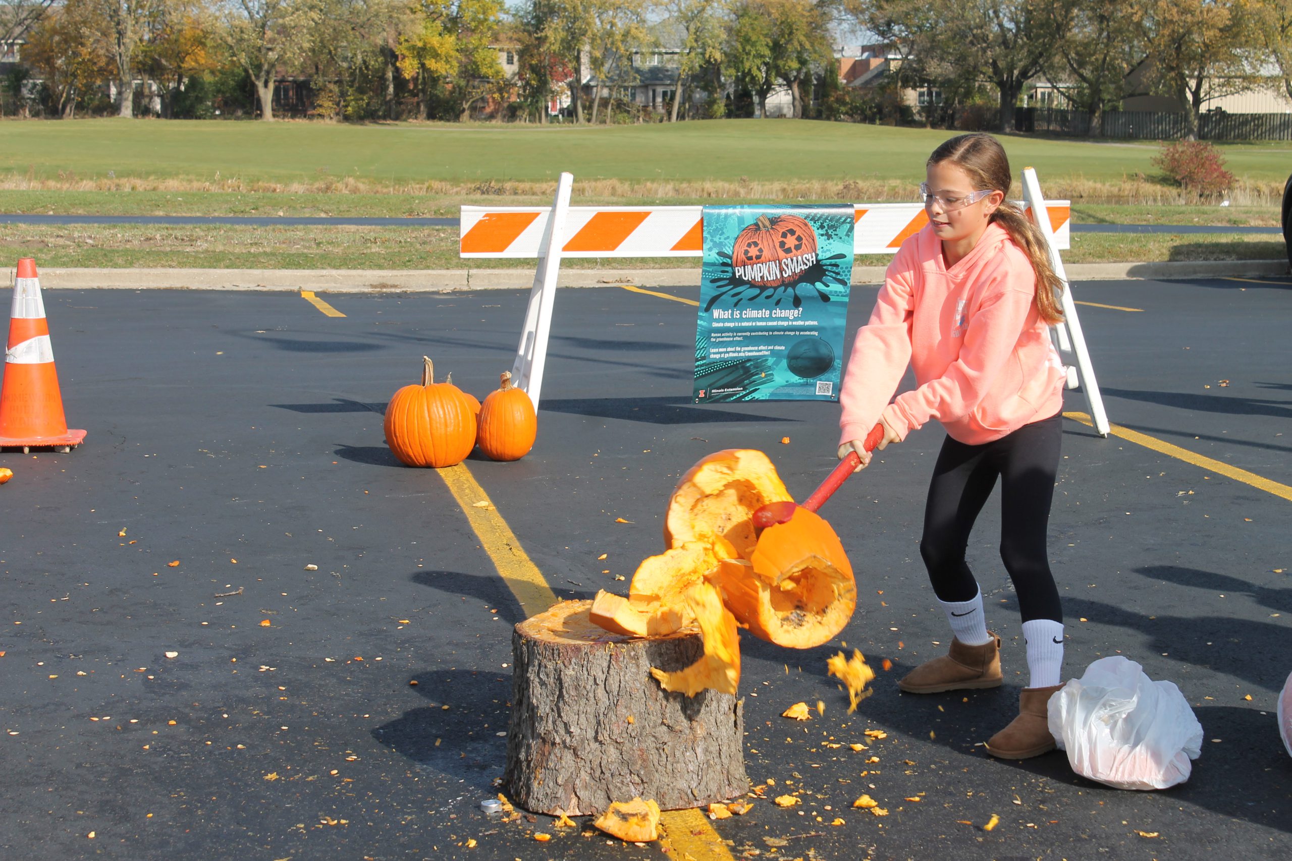 photo of child smashing a pumpkin with a mallet.