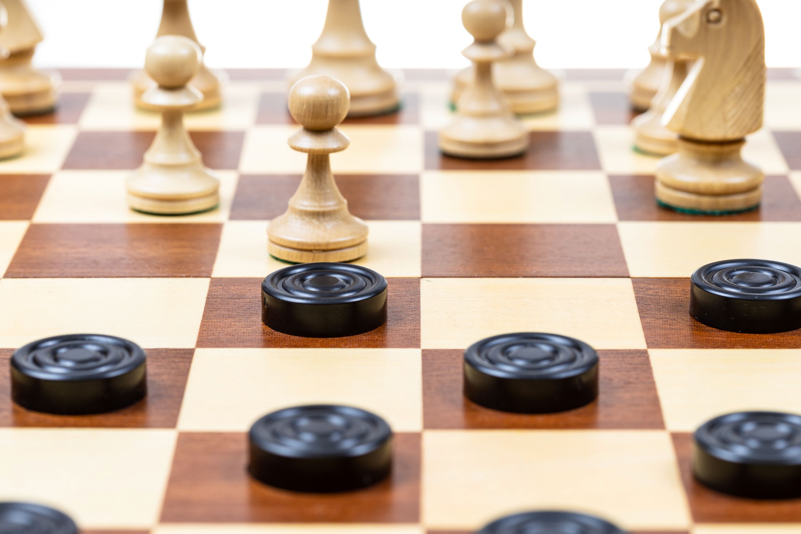 photo of chess and checker pieces on a board