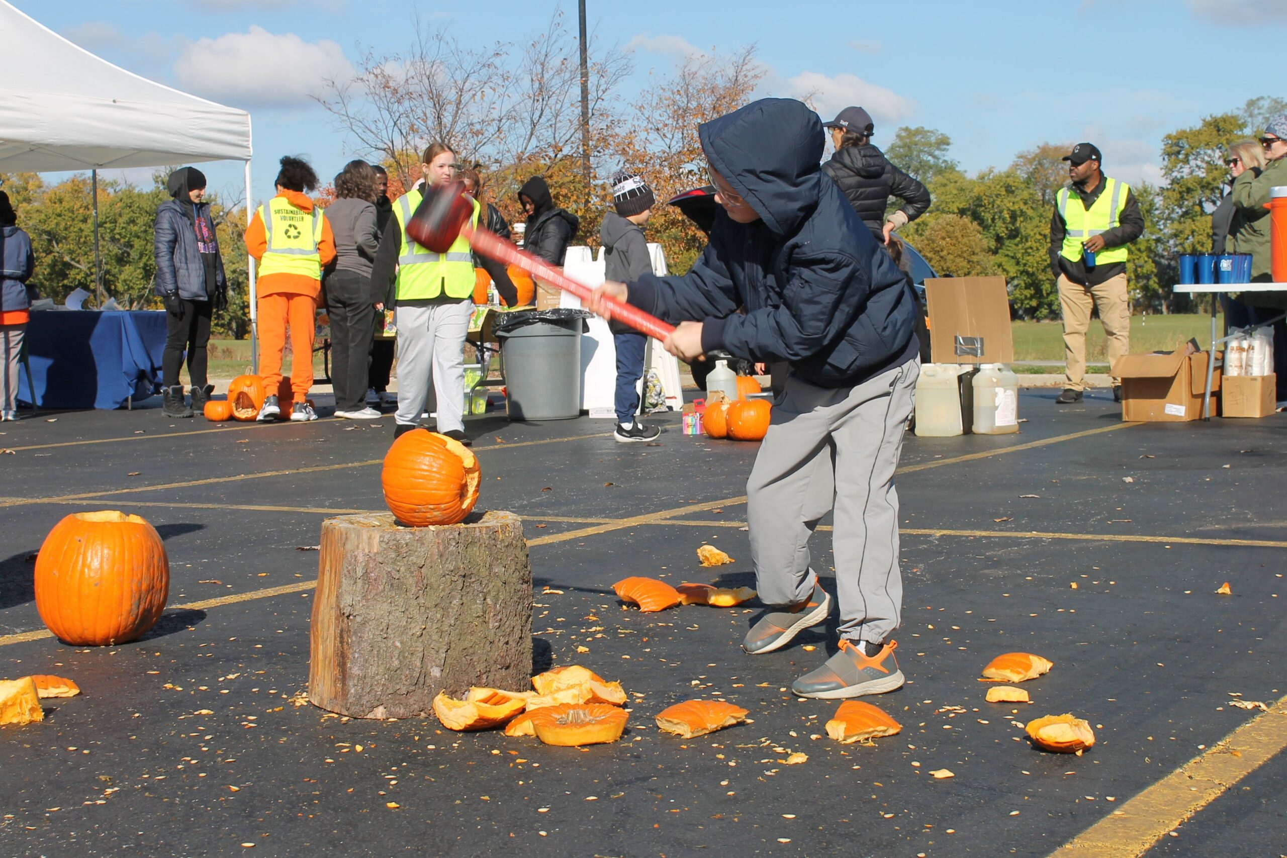 photo of child smashing a pumpkin with a mallet.
